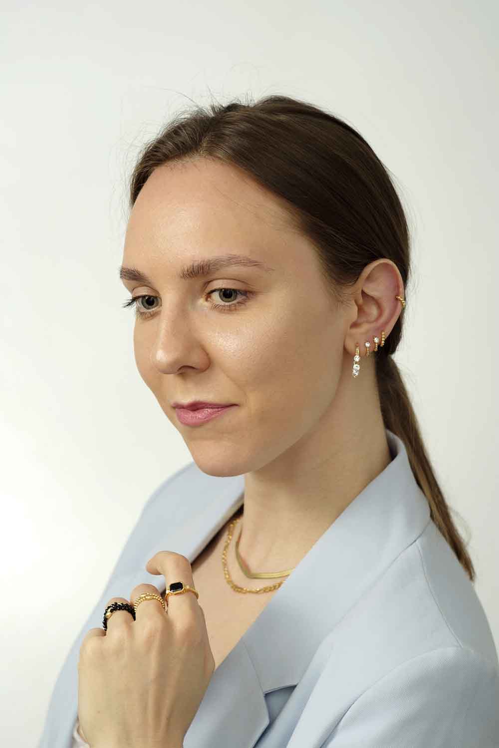 Gold rings on the hand. Jewelry with white zircons.
